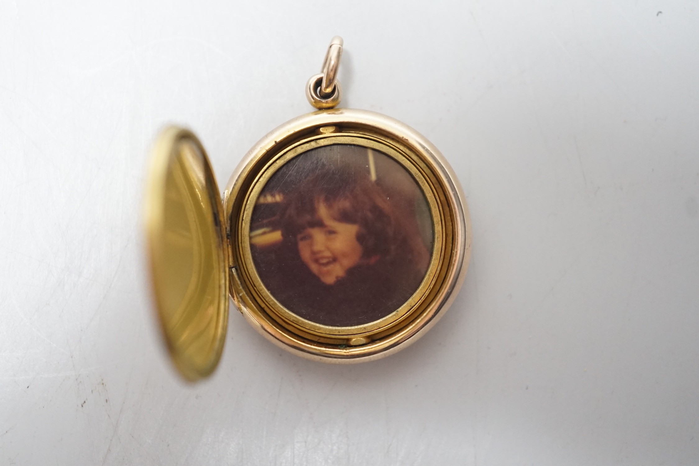 A 9ct gold mounted circular triptych locket, diameter 29mm, gross weight 10.8 grams.